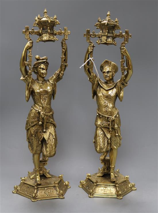 A pair of cast brass chinoiserie candlesticks with swivel sconces, height 41cm